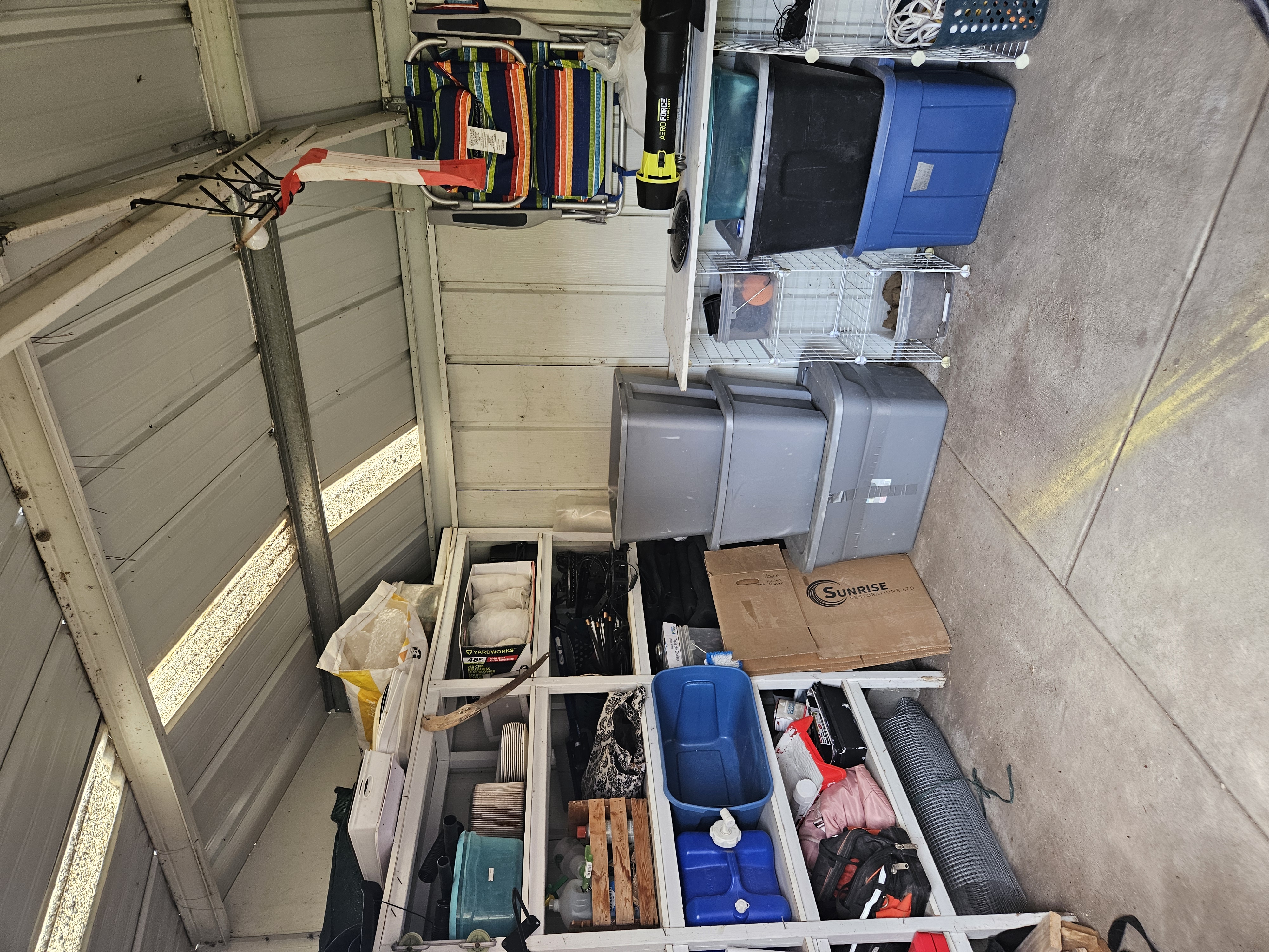 The shed after — tools on hooks, pots stacked, floor visible, room to breathe